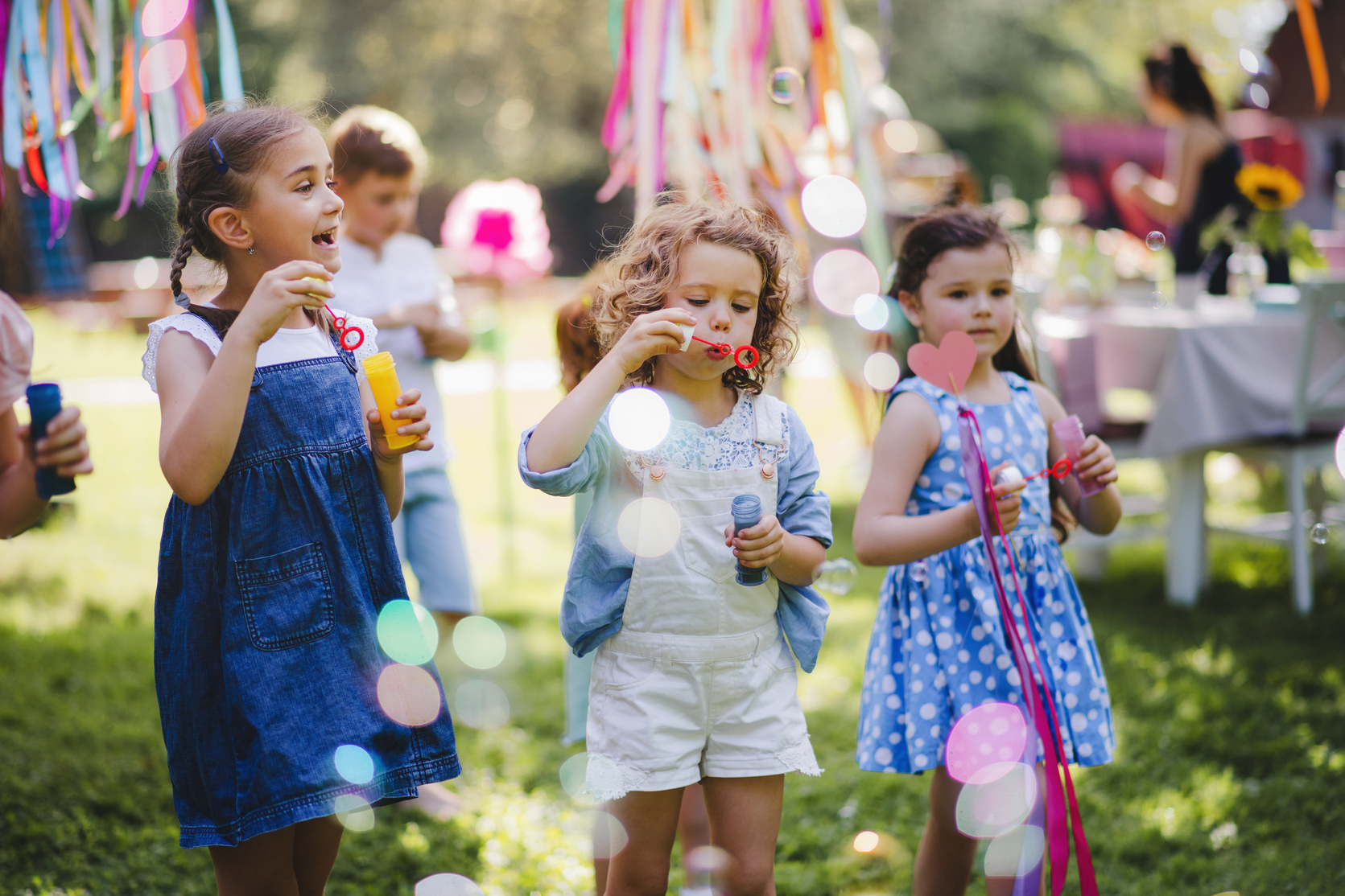 Children Blowing Bubbles Together at a Party